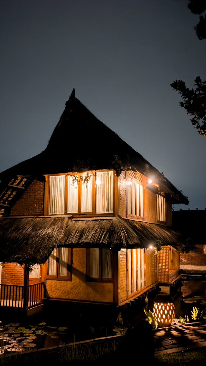 Stunning nighttime view of a traditional bamboo house illuminated by warm lighting.