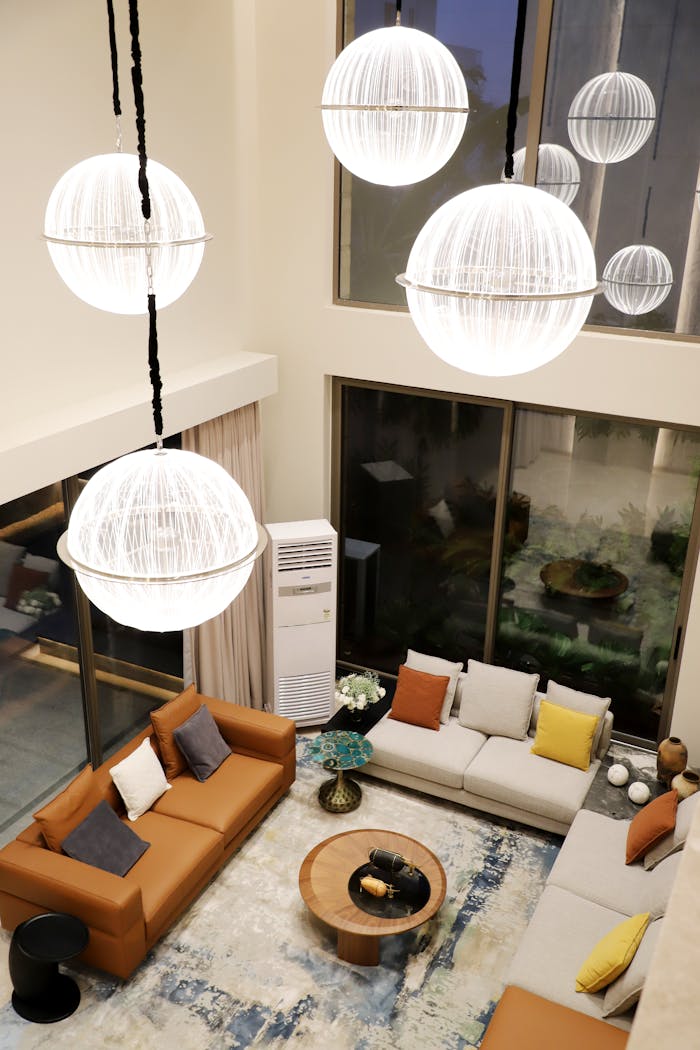 Stylish modern living room featuring large spherical pendant lights, cozy couches, and a coffee table.